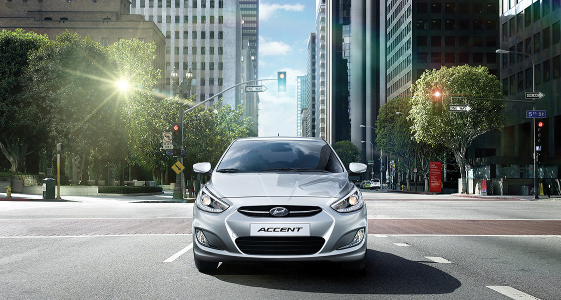 منظر أمامي لسيارة أكسنت الرمادية في منتصف أحد شوارع المدينة