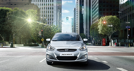 منظر أمامي لسيارة أكسنت الرمادية في منتصف أحد شوارع المدينة