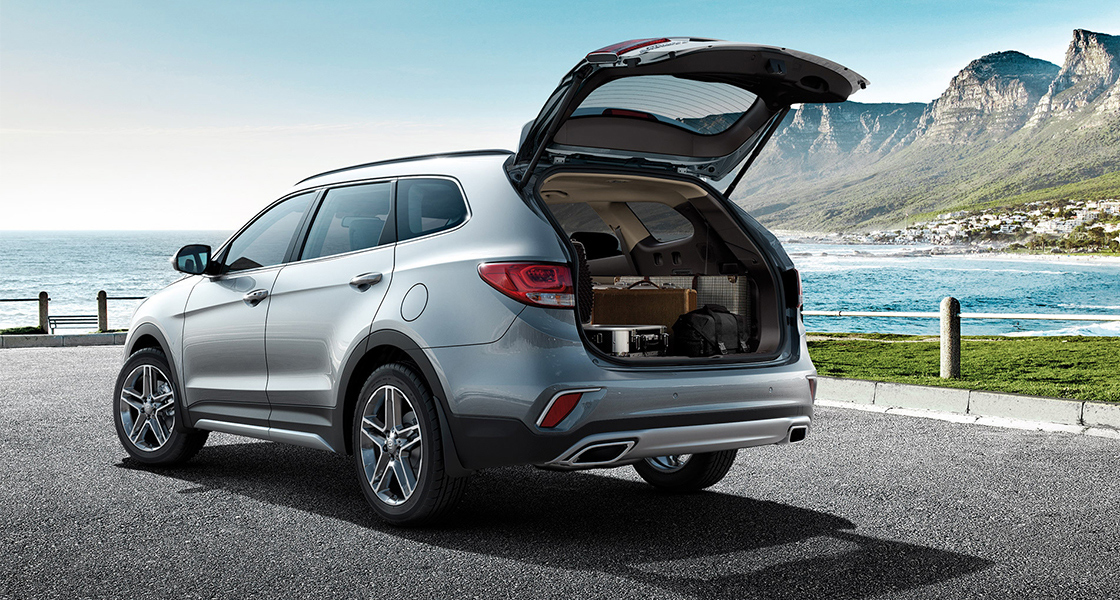 صورة خلفية جانبية لسيارة جراند سنتافي فضية اللون وحقيبتها الخلفية مفتوحة