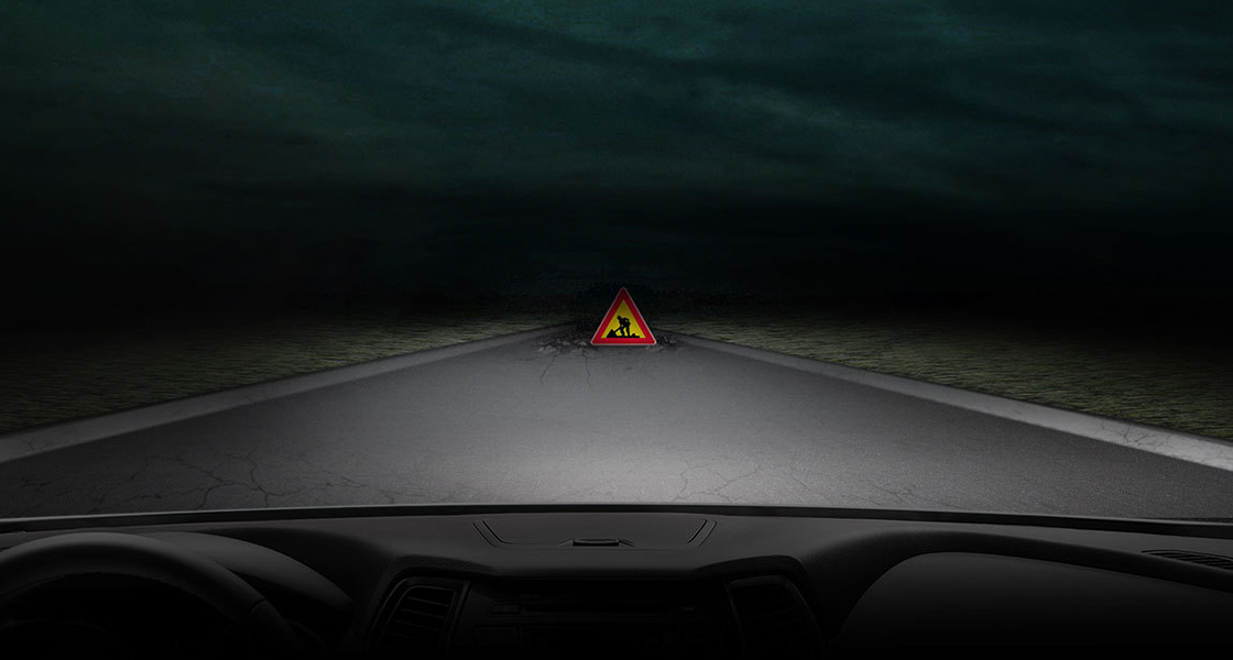 منظر للطريق مع وجود إشارة مرور تحذيرية في الظلام