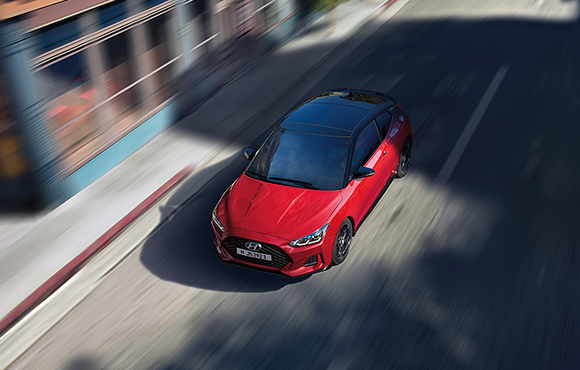 Left side top view of red veloster driving on the road