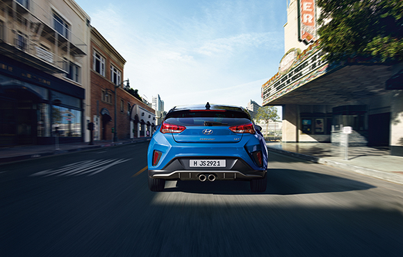 Rear view of blue veloster driving on the road