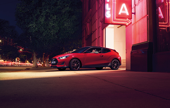 Left side view of red veloster parking