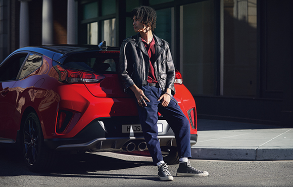 Left side rear view of red veloster parking on the road