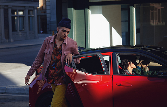 Side view of red veloster parking on the road
