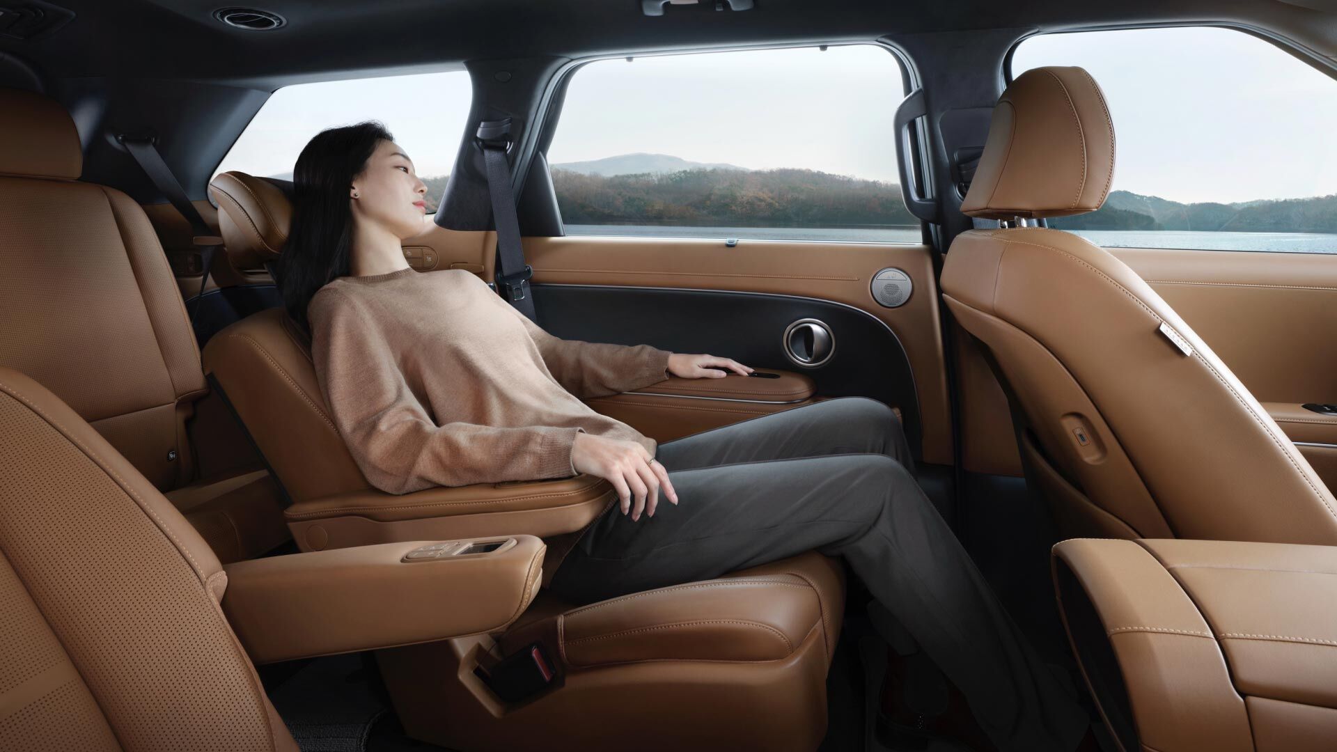 A woman relaxing in the second row seat inside the all-new PALISADE