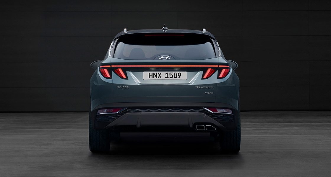 Side-front view of orange Grandi10 with lakeside view at night